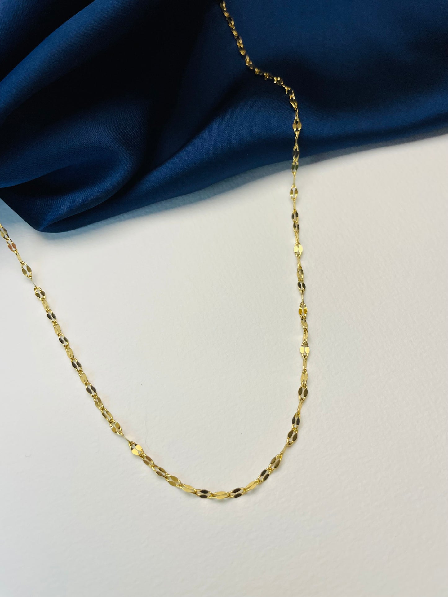 Le collier Claire est en acier inoxydable. Chaîne fine avec ses maillons écrasés qui captent la lumière ce qui lui donne toute sa brillance ! bijoux fantaisie Clotaire-R